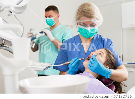 Female dentist with girl patient during oral checkup Female dentist with girl patient during oral checkup 57122736
