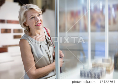 Adult female looking at artwork copper exhibit in the gallery indoors Adult female looking at artwork copper exhibit in the gallery indoors 57122761