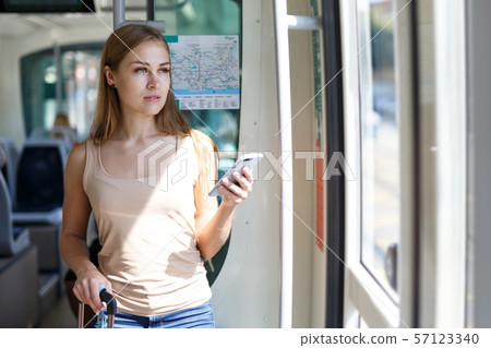 Woman using phone inside subway Woman using phone inside subway 57123340