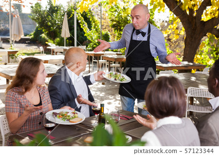 Restaurant guests complain about the food to the waiter Restaurant guests complain about the food to the waiter 57123344