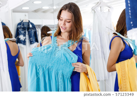 Girl trying new dress in front of mirror Girl trying new dress in front of mirror 57123349
