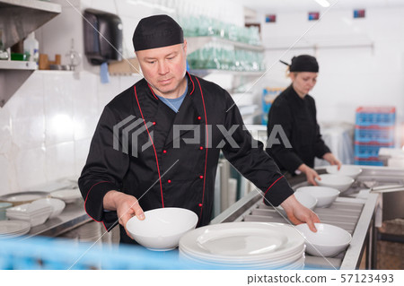 Man preparing plates for setting 57123493