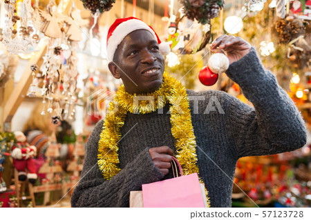 Man in Santa hat looking for New Year decorations 57123728