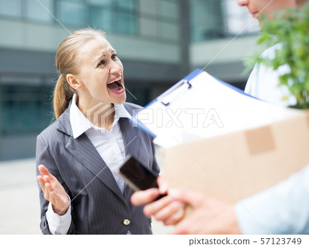 Irate woman is dismissing young manager for violating the job description Irate woman is dismissing young manager for violating the job description 57123749