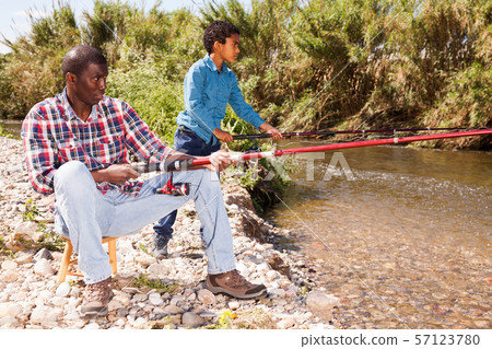 Man and boy fishing with rods Man and boy fishing with rods 57123780