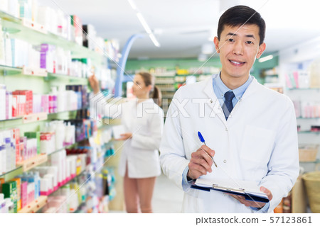 Pharmacist stocktaking medicines in drugstore Pharmacist stocktaking medicines in drugstore 57123861