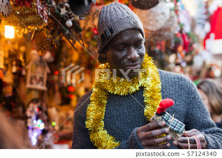 Man selecting festive Christmas decoration Man selecting festive Christmas decoration 57124340