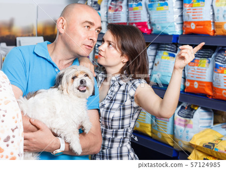 Portrait of family couple with dog choosing dry food in pet store 57124985