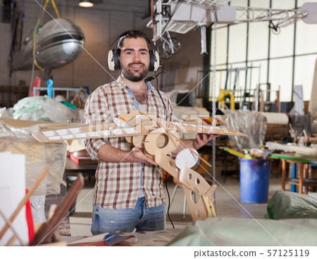 Male in aviator headphones with airplane models Male in aviator headphones with airplane models 57125119