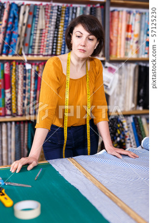 Woman seller of tissue store near cutting table Woman seller of tissue store near cutting table 57125230