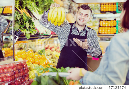 Male seller assisting in buying 57125274