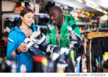 Multiracial couple choosing ski boots Multiracial couple choosing ski boots 57125424