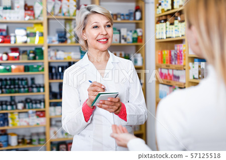 Mature female seller suggesting care products to young customer Mature female seller suggesting care products to young customer 57125518