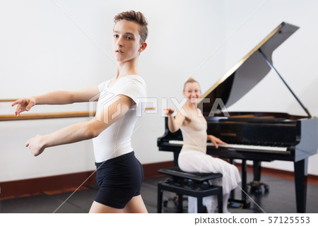 Ballet lesson in the studio. Choreographer plays the piano 57125553