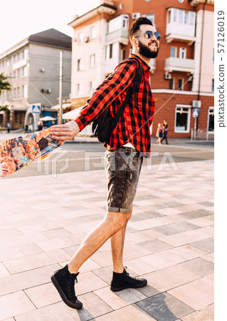 guy with a beard in sunglasses, walks with a 57126019