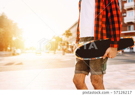 guy with a beard with a skateboard at sunset. guy with a beard with a skateboard at sunset. 57126217