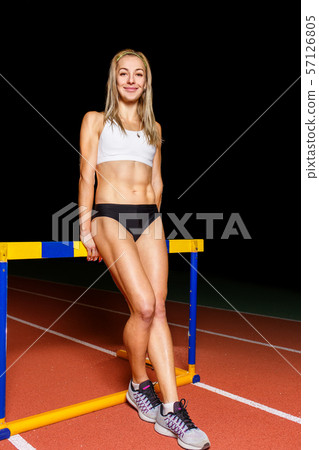 Young athletic woman standing at the hurdle Young athletic woman standing at the hurdle 57126805