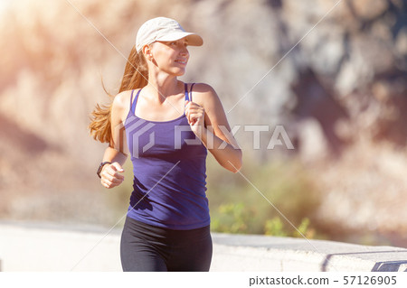 Slim woman in blue top running in the morning. 57126905