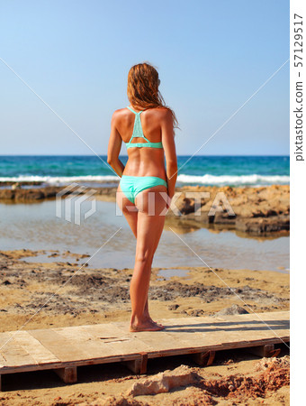 Athletic young brunette woman in cyan bikini Athletic young brunette woman in cyan bikini 57129517