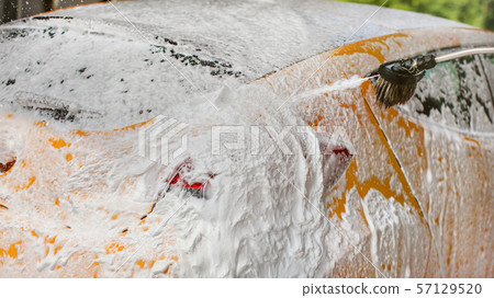 Yellow car completely covered with shampoo and Yellow car completely covered with shampoo and 57129520
