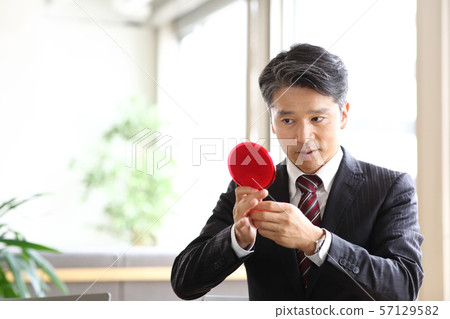 Businessman with mirror Businessman with mirror 57129582