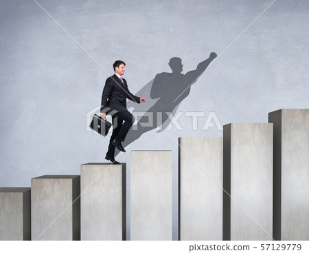 Businessman rise up on the career ladder with superhero shadow on the wall. 57129779
