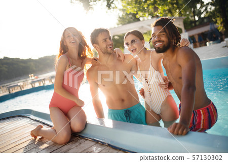 Strong boyfriends hugging their women while chilling in pool Strong boyfriends hugging their women while chilling in pool 57130302
