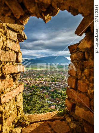 Landscape of Rasnov town and Carpathian mountains through the window of the fortress wall of Citadel. Brasov County, Transylvania, Romania. 57130381