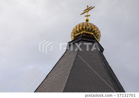 Close-up of black roof shingle of church with golden cross on top Close-up of black roof shingle of church with golden cross on top 57132701