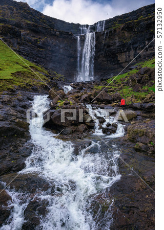 Tourist at the Fossa Waterfall on island Bordoy in the Faroe Islands 57132950