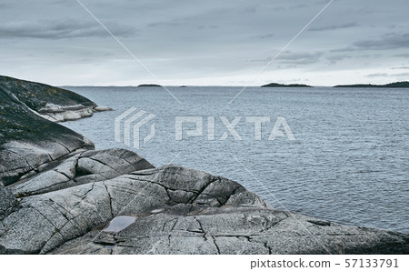 Rocky sea shore on an overcast day background Rocky sea shore on an overcast day background 57133791