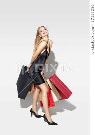 Young woman in dress shopping on white background 57135256
