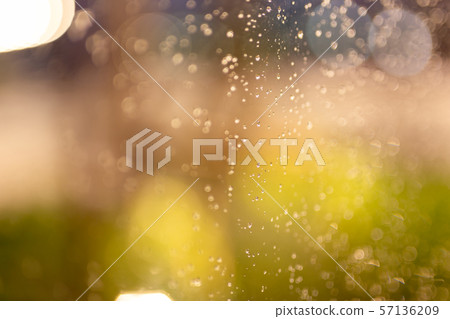 Water rain drops on window glass with colorful bokeh lighting in background. Water rain drops on window glass with colorful bokeh lighting in background. 57136209