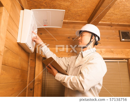 Worker checking the distribution board Worker checking the distribution board 57138756
