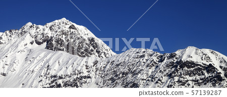 Snowy mountains and blue clear sky at cold sun day Snowy mountains and blue clear sky at cold sun day 57139287