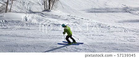 Skier downhill on snowy ski slope at sunny winter Skier downhill on snowy ski slope at sunny winter 57139345