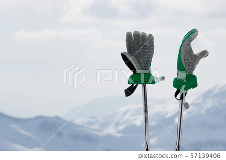 Gloves on ski poles and snowy winter mountain Gloves on ski poles and snowy winter mountain 57139406