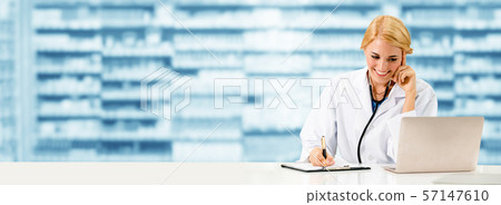 Pharmacist using laptop computer at pharmacy. Pharmacist using laptop computer at pharmacy. 57147610
