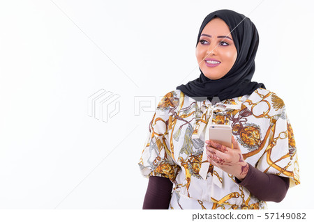 Happy young beautiful African Muslim woman thinking while using phone Happy young beautiful African Muslim woman thinking while using phone 57149082