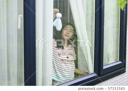 A child watching the rain from the window 57151583