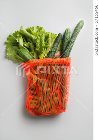 Shopping net bag with greens and vegetables. Shopping net bag with greens and vegetables. 57155456
