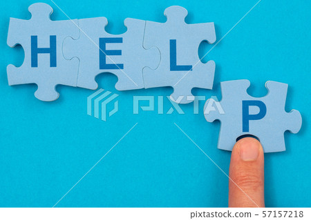 Finger and puzzle with word HELP on the blue 57157218