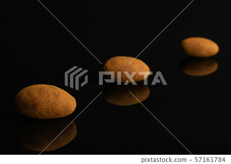 Chocolate cinnamon almond isolated on black glass Chocolate cinnamon almond isolated on black glass 57161784