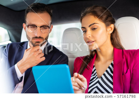 Couple of businessmen reading financial news on the way to work Couple of businessmen reading financial news on the way to work 57161798