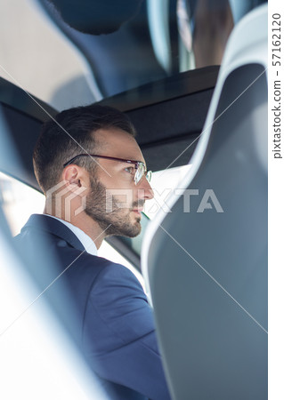 Handsome bearded man wearing glasses driving his car Handsome bearded man wearing glasses driving his car 57162120