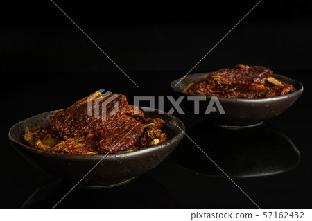 Red dried tomato isolated on black glass 57162432