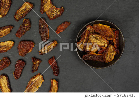 Red dried tomato on grey stone Red dried tomato on grey stone 57162433