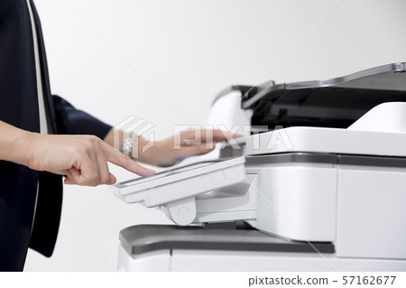 Woman hand taking a copy with a copy machine Woman hand taking a copy with a copy machine 57162677
