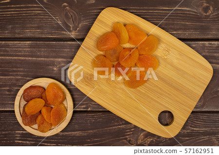 Dried orange apricot on brown wood Dried orange apricot on brown wood 57162951