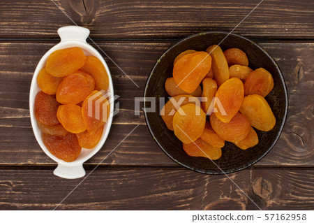 Dried orange apricot on brown wood 57162958